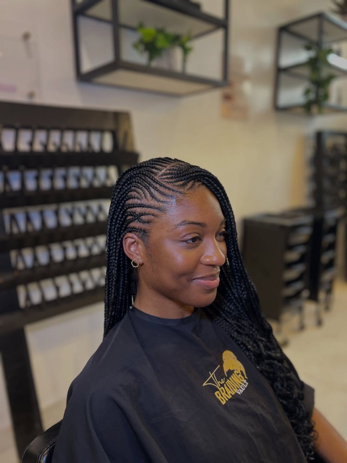Woman wearing long black braids with loose wavy curls at the ends