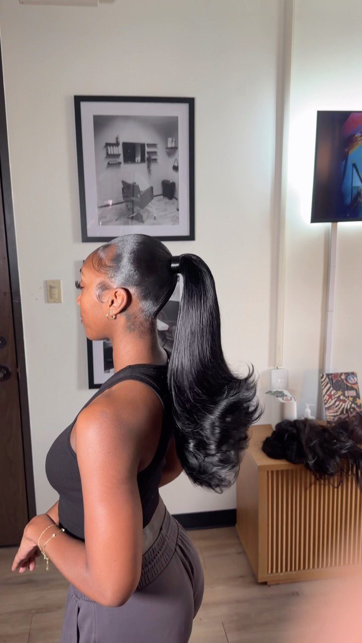 Woman wearing a sleek, long ponytail with curled ends