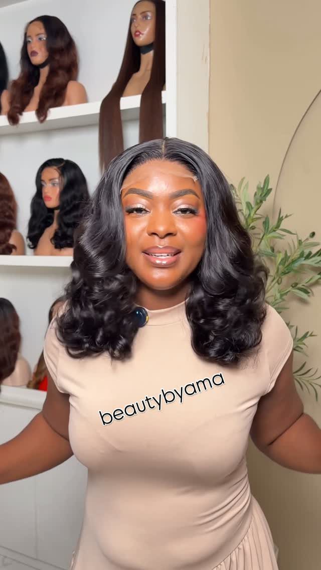 Woman models a dark wavy wig with shoulder-length curls