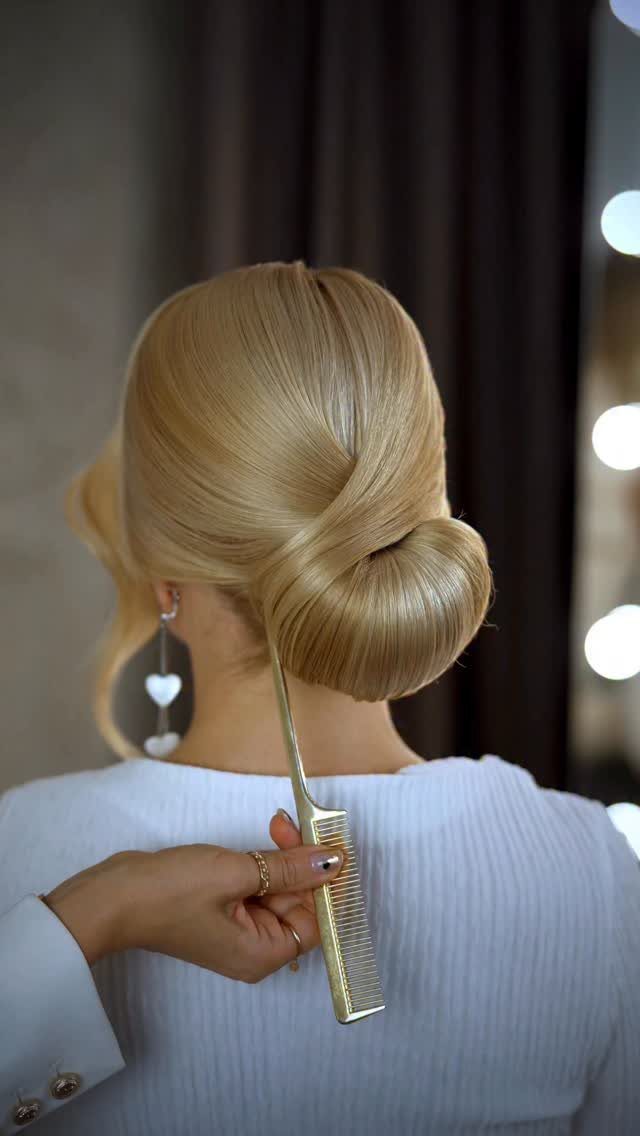 Blonde low bun styled smoothly at the nape with a gold comb
