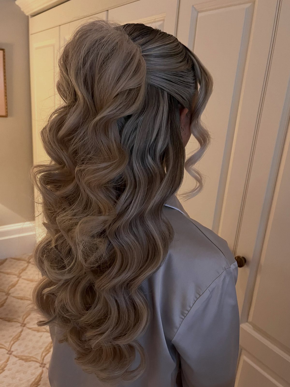 Long curled hair styled half-up with a dark claw clip