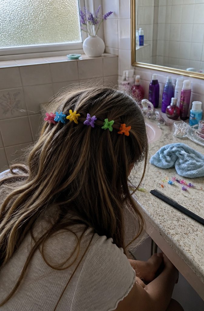 Small colorful butterfly clips arranged across a half-up hairstyle