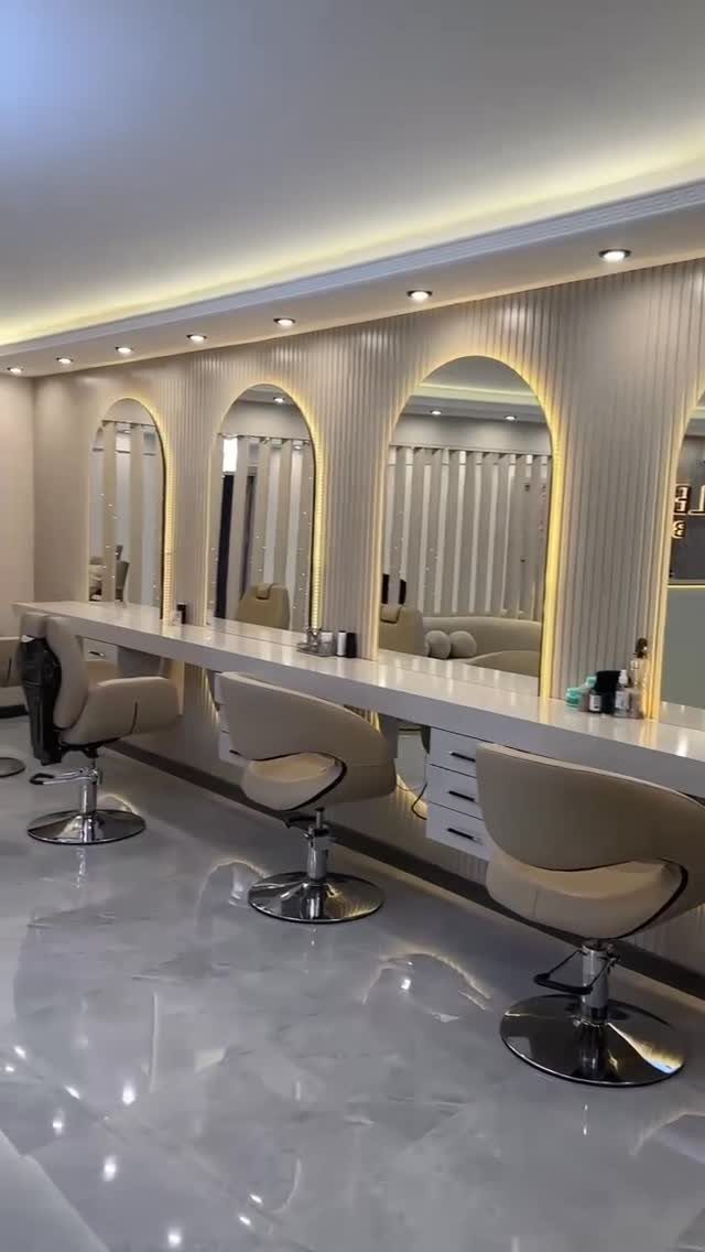 Modern hair salon with cream styling chairs, arched mirrors, and a glossy floor