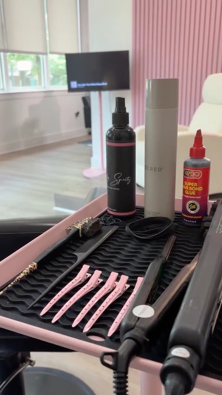 Aesthetic hair salon workstation displaying pink combs, styling tools, and hair products