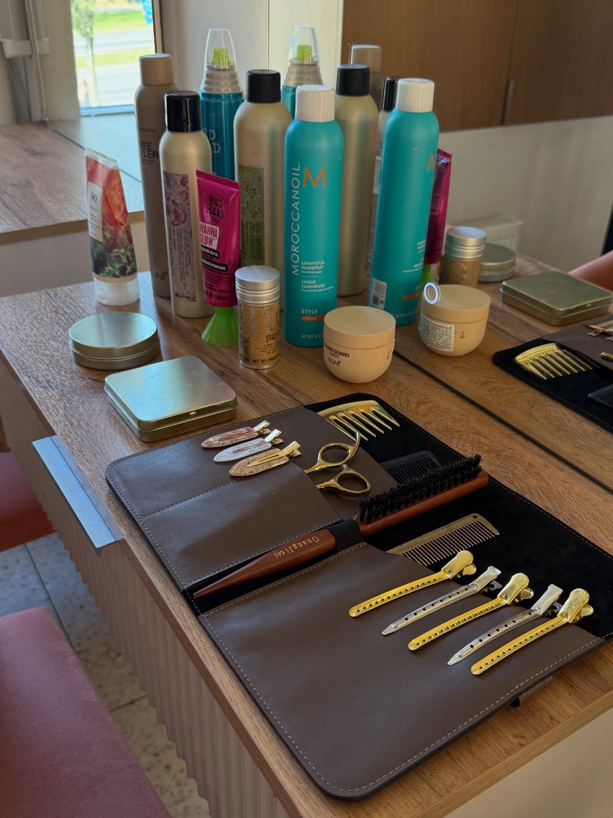 Salon counter displaying hair products, brushes, combs, clips, and styling tools