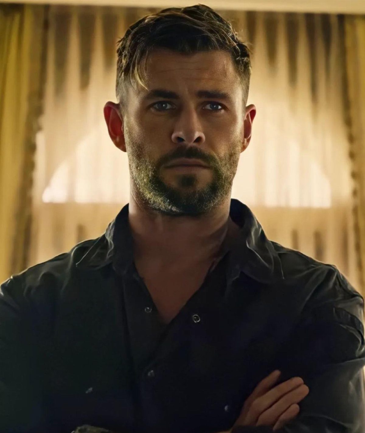 Man with short textured brown hair and a neatly trimmed full beard