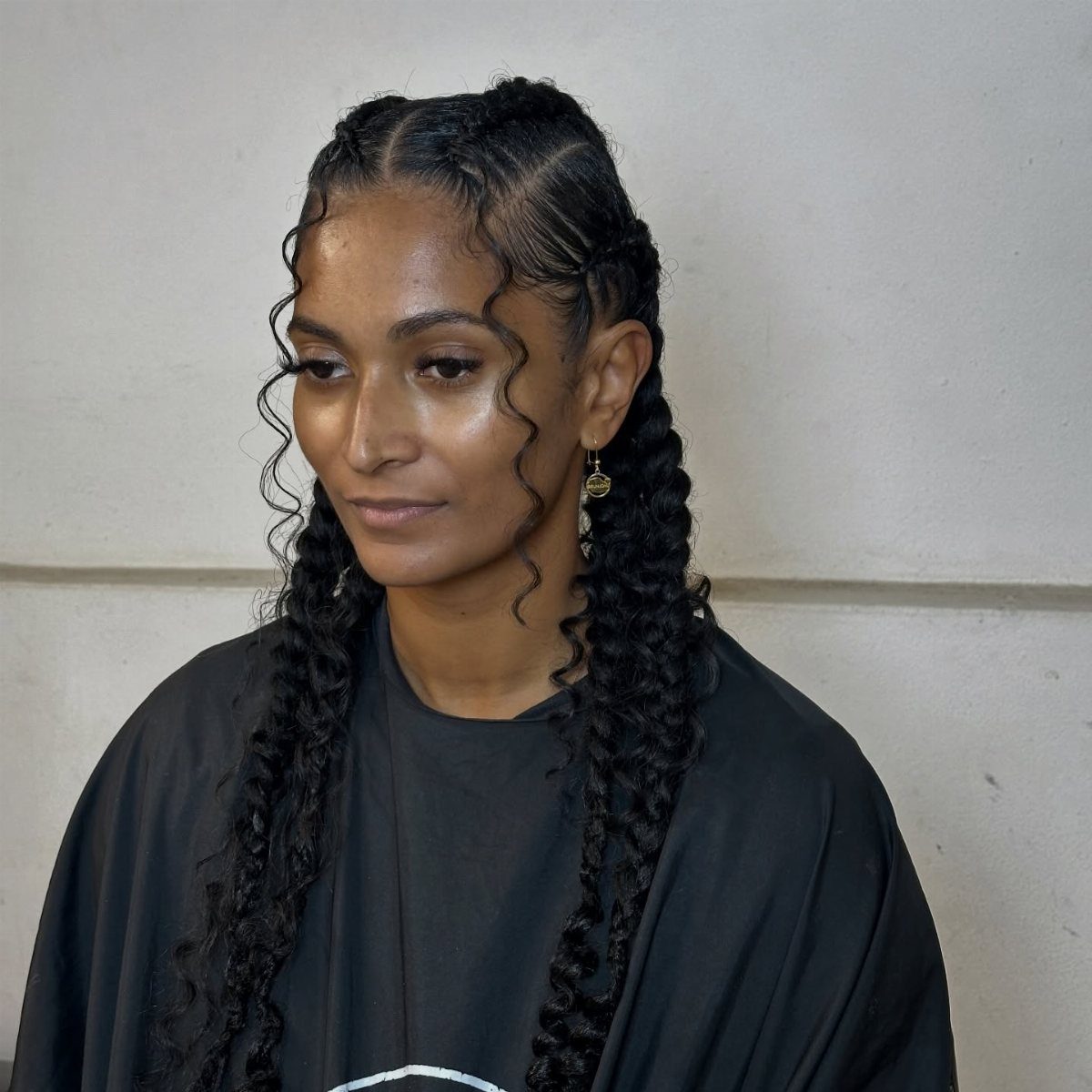 Woman wearing black cornrows with long textured braids and face-framing curls
