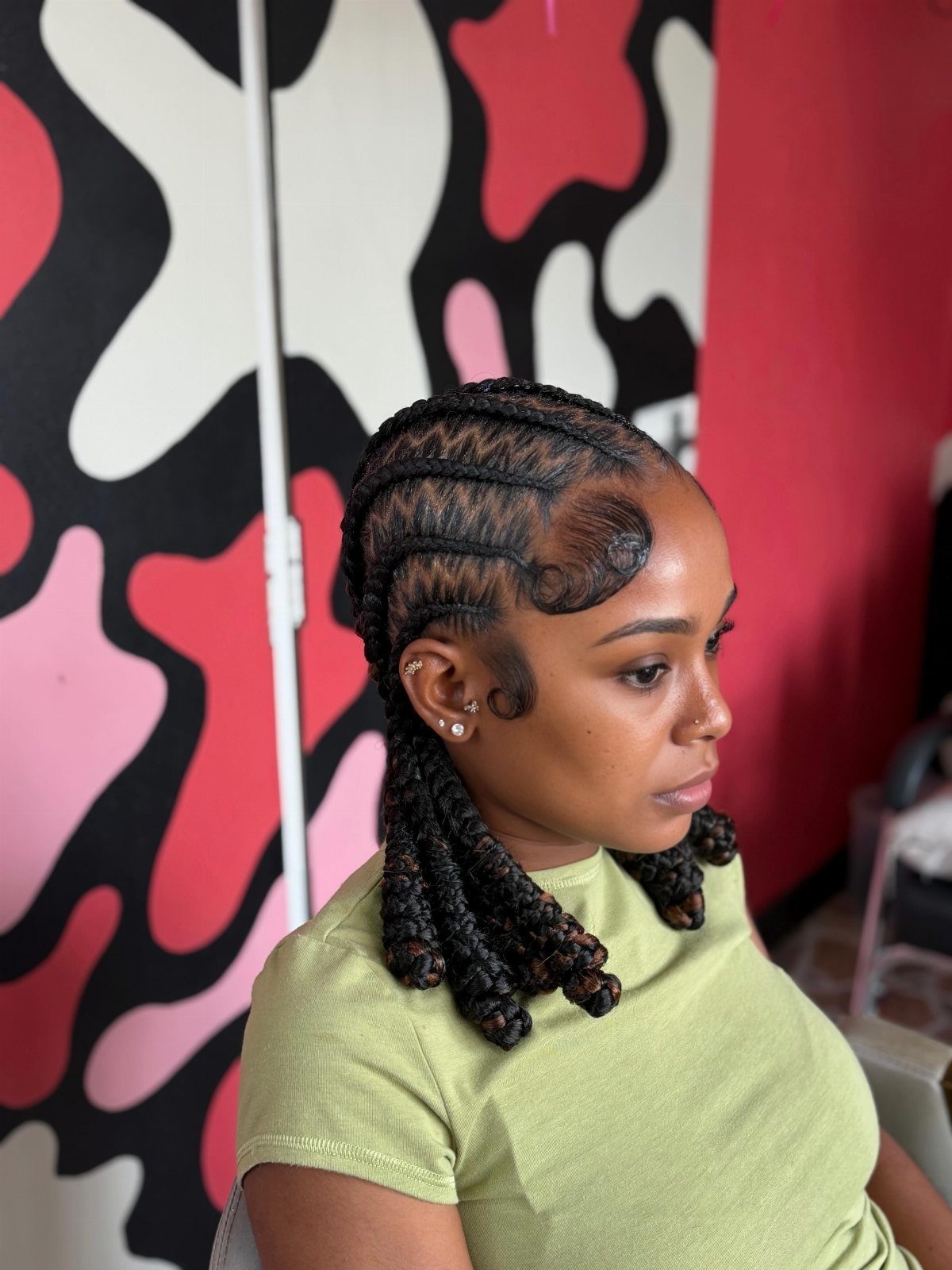 Woman displaying cornrows braided back into thick curled braids