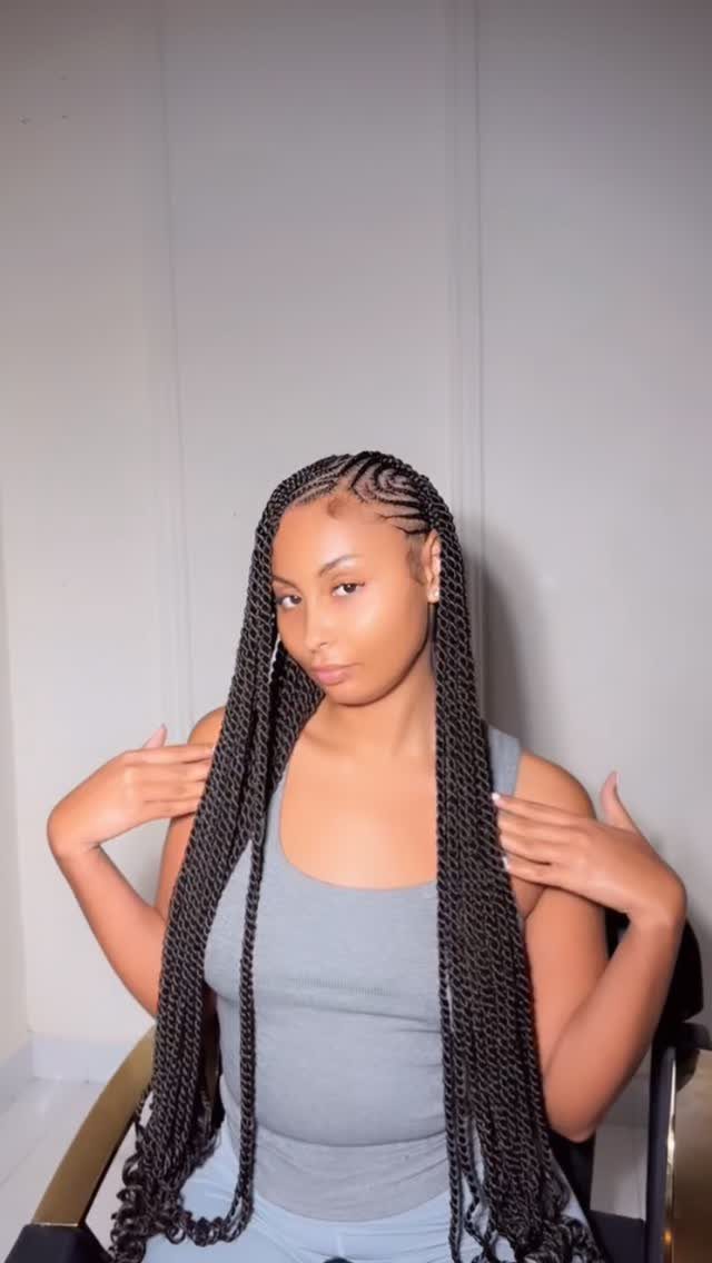 Woman posing with long black braids and curved cornrows across her scalp