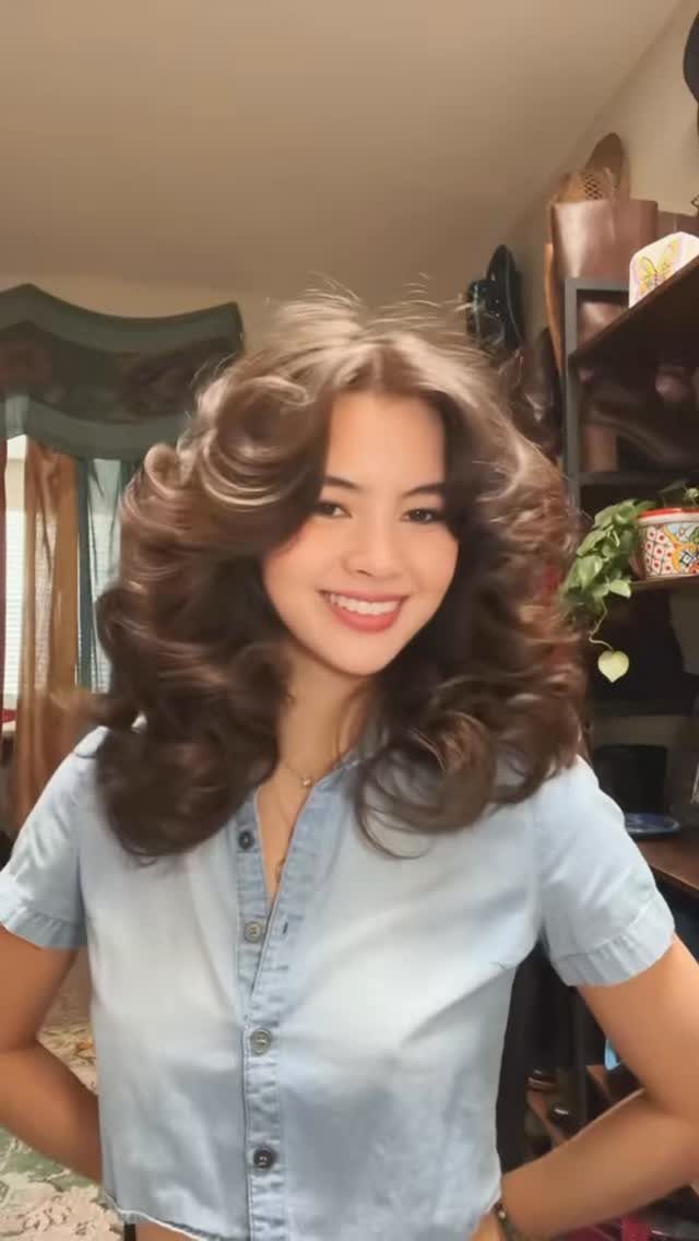 Woman showing long brown hair with voluminous 90s-style flipped curls