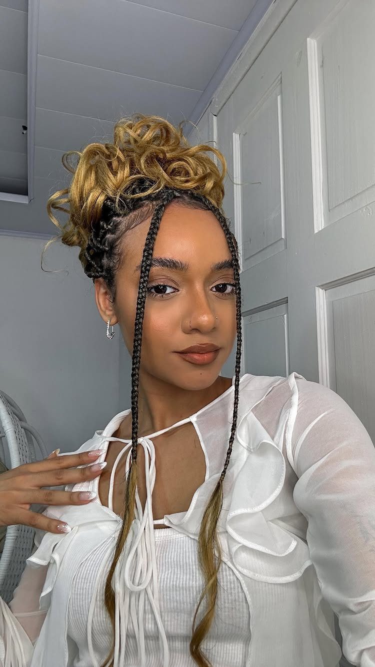 Woman with a curly blonde updo and two long face-framing braids