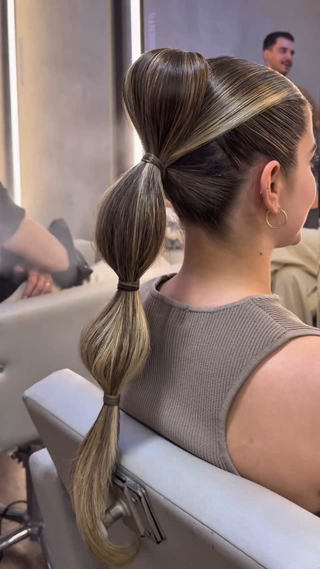 Bubble ponytail with sleek hair and several puffed sections secured by elastics