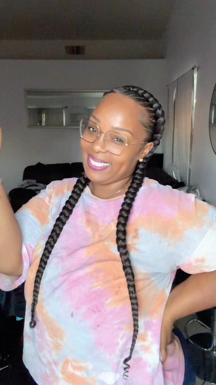 Woman showing two long Dutch braids with a center part