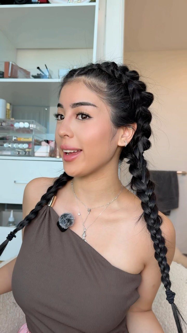 Woman wearing two thick scalp-hugging Dutch braids in a bright room