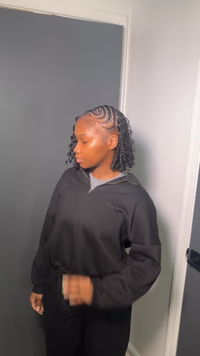 Cornrowed hair swept back into short curls on a person in a black sweatshirt