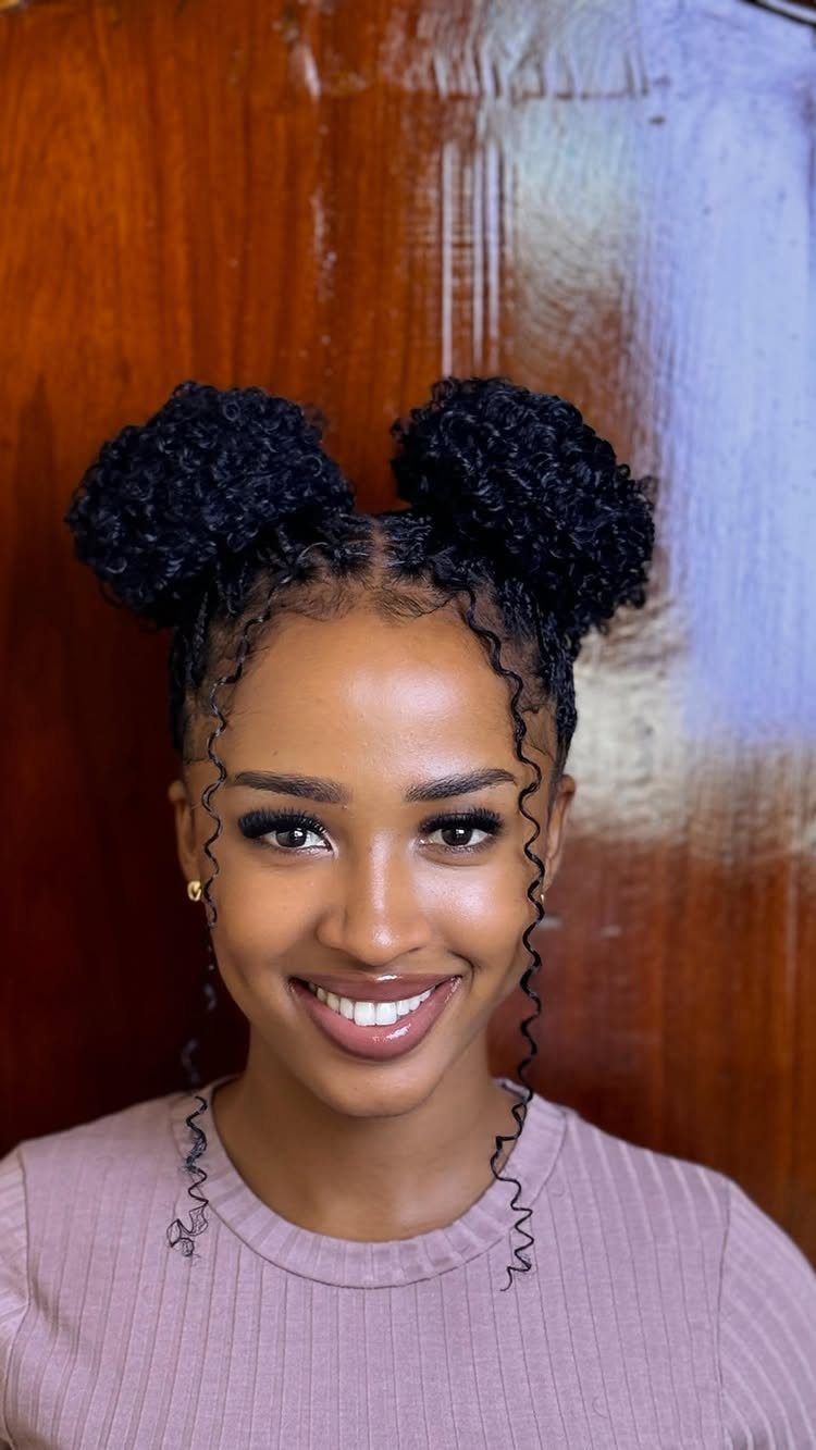 Woman with two high curly puff buns and face-framing tendrils