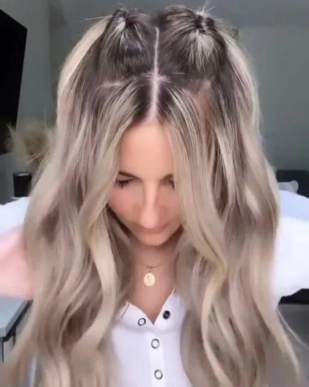 Half-up hairstyle with two topsy-tail twists and long loose blonde waves