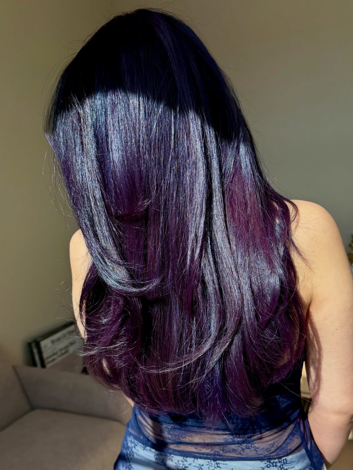 Long near-black plum hair with subtle violet tones and layered, wavy ends