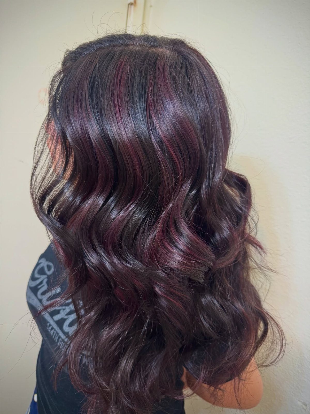Long dark plum waves show subtle darker lowlights and reddish-purple sheen