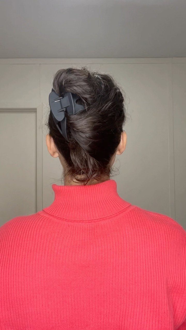 Brown hair gathered into an updo and secured with a dark claw clip