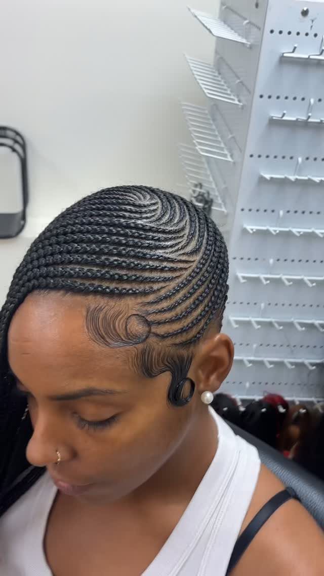 Cornrow braids curve neatly across a woman's scalp with sculpted baby hairs