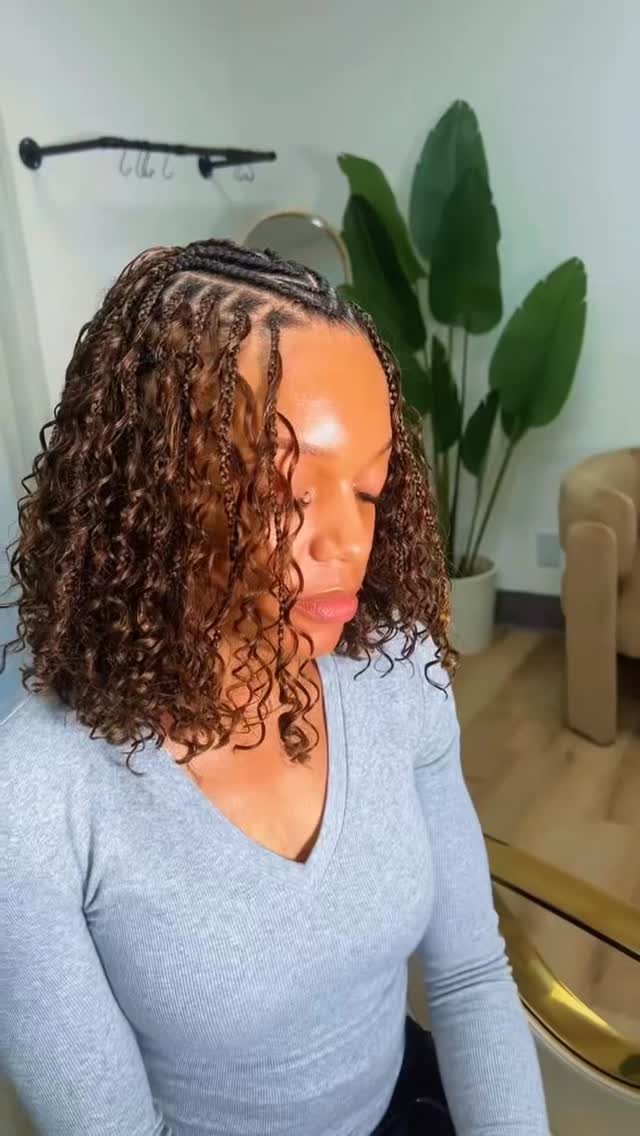 Woman showing small knotless braids transitioning into loose curls