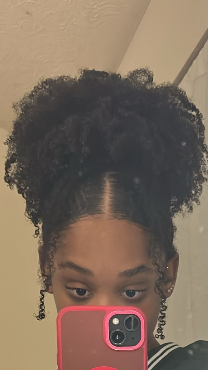 Natural hair styled in two large curly puffs with a center part