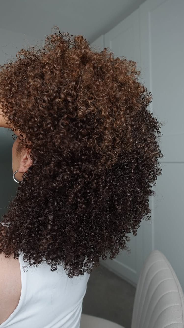 Voluminous natural tight curls with dark brown and copper tones