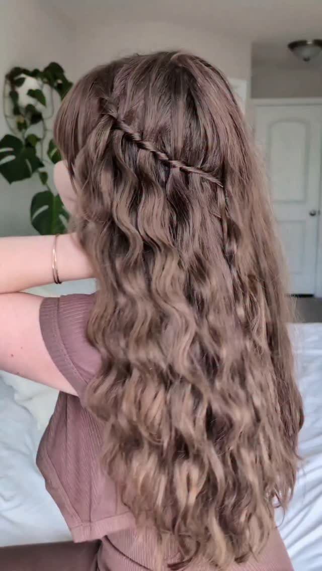 Long wavy hair with a waterfall braid across the back