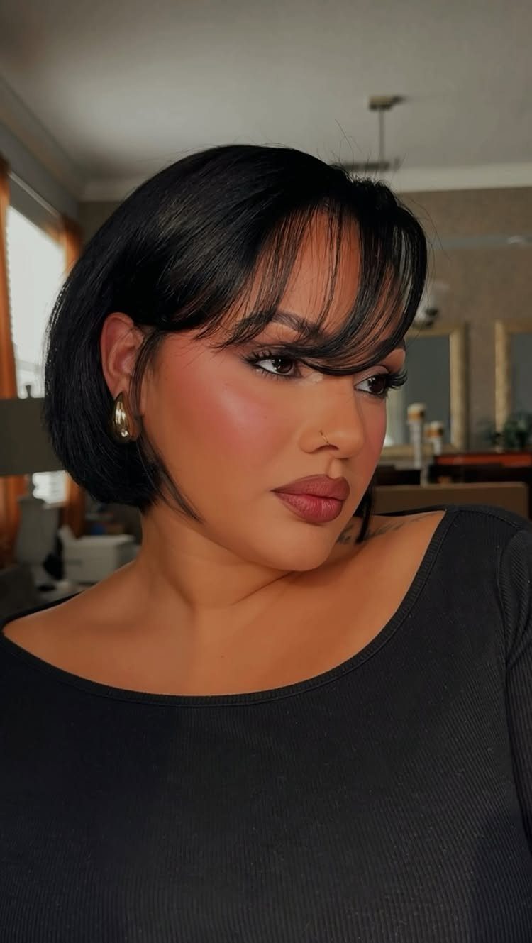 Woman wearing a polished black French bob with softly parted bangs