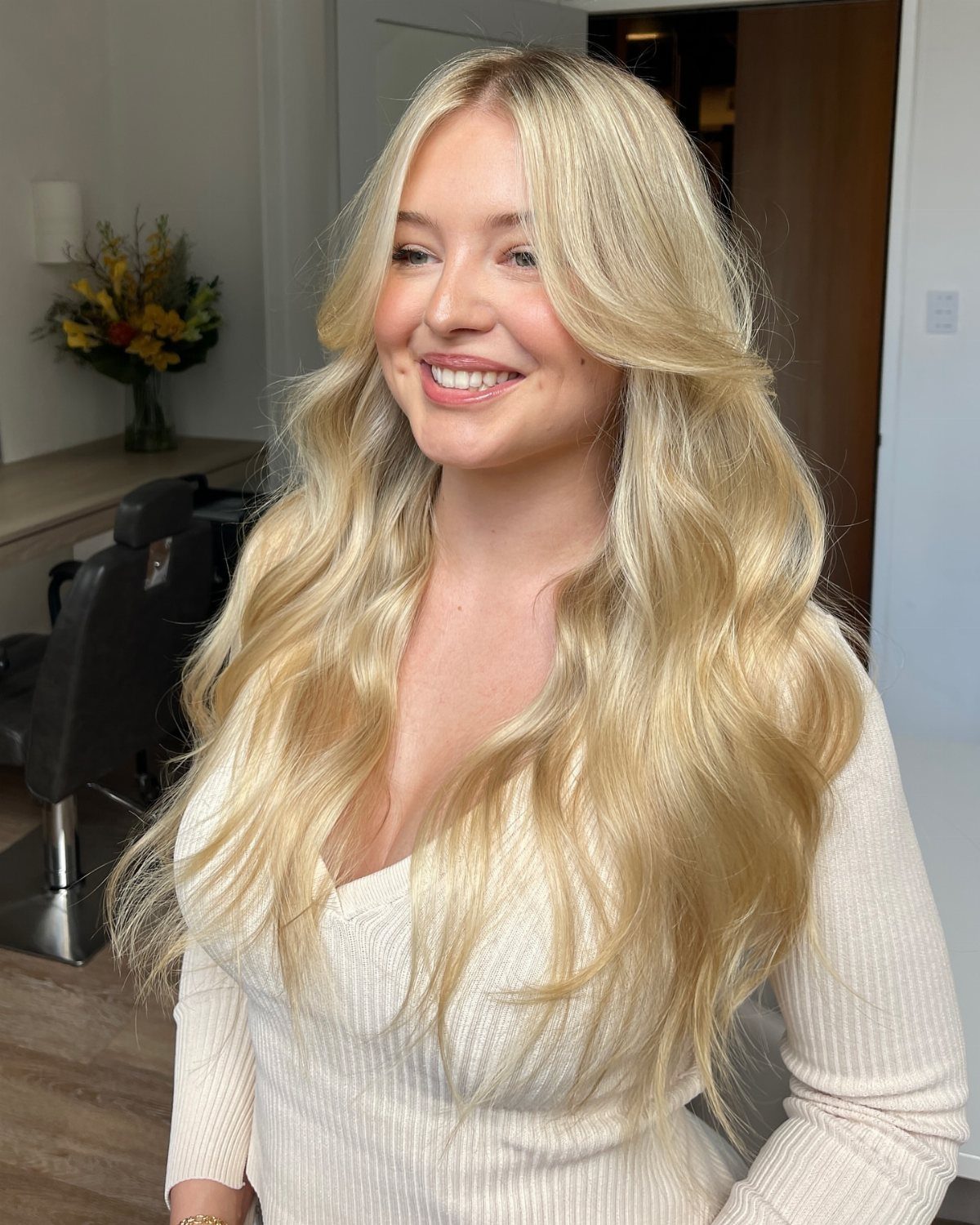 Woman with long, lustrous golden blonde waves in a salon