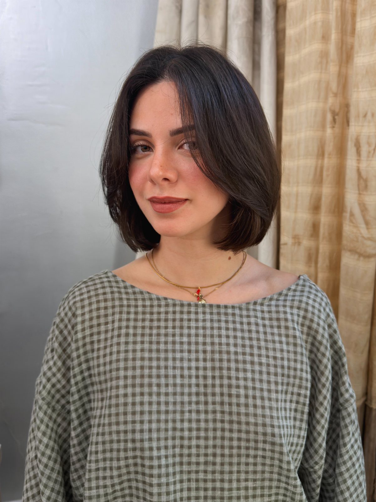 Woman posing with a dark, chin-length bob and softly curved ends