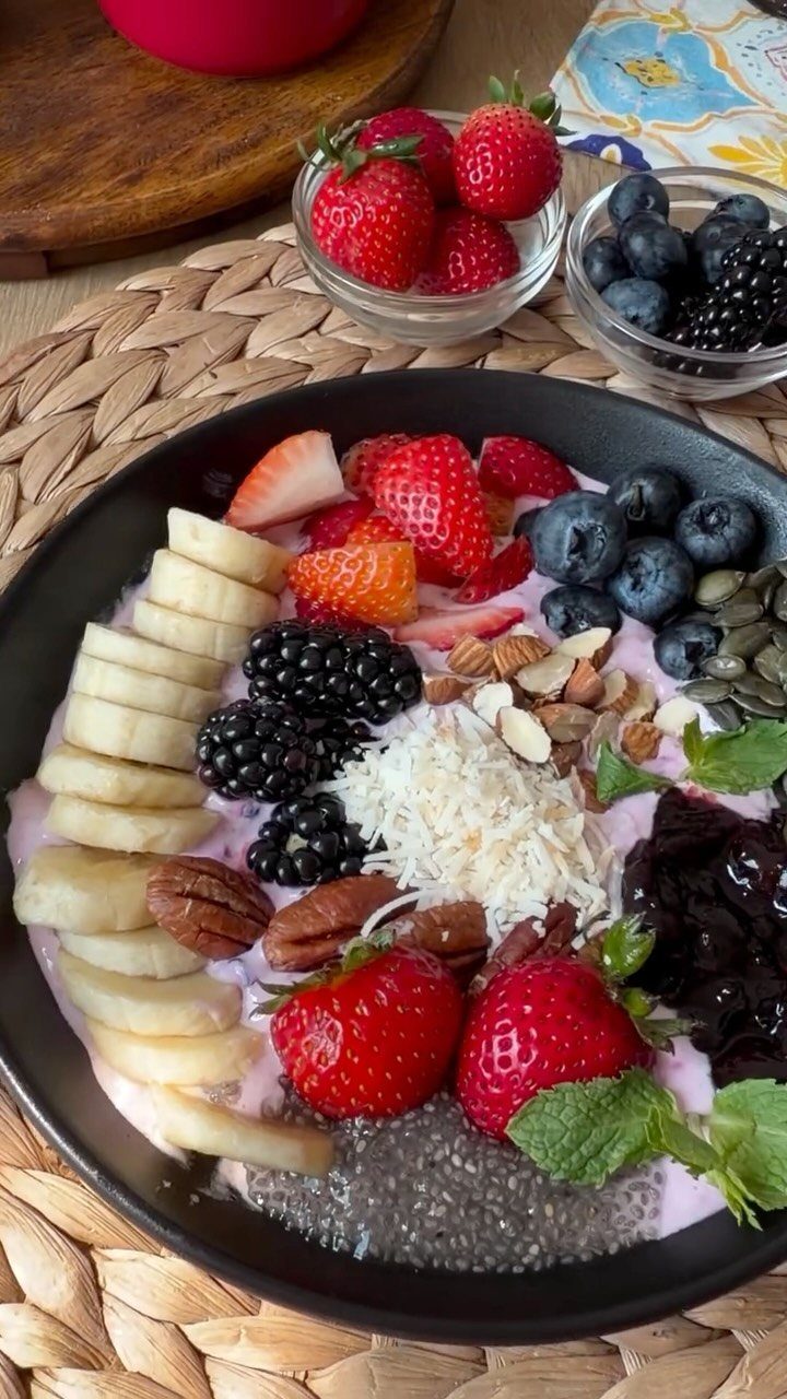 Berry-topped smoothie bowl with strawberries, blueberries, blackberries, banana and coconut
