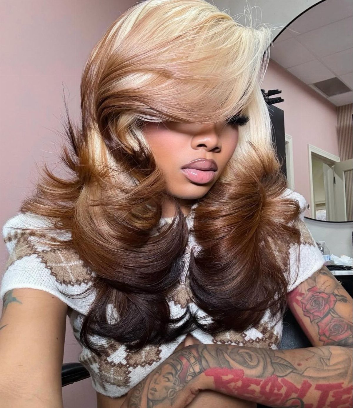 Layered blonde hair with dark lowlights and voluminous curled ends