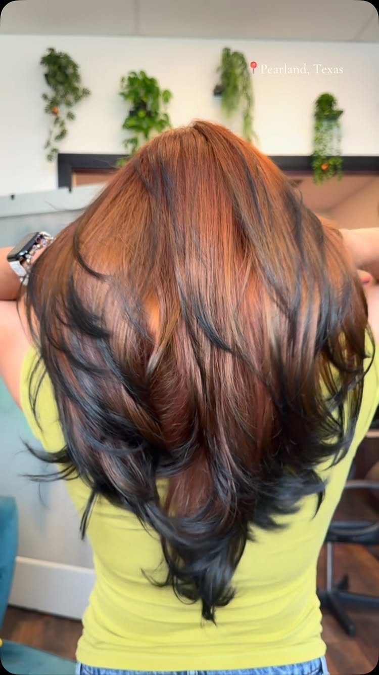 Copper-red layered hair falls into a long, tapered V-shaped silhouette