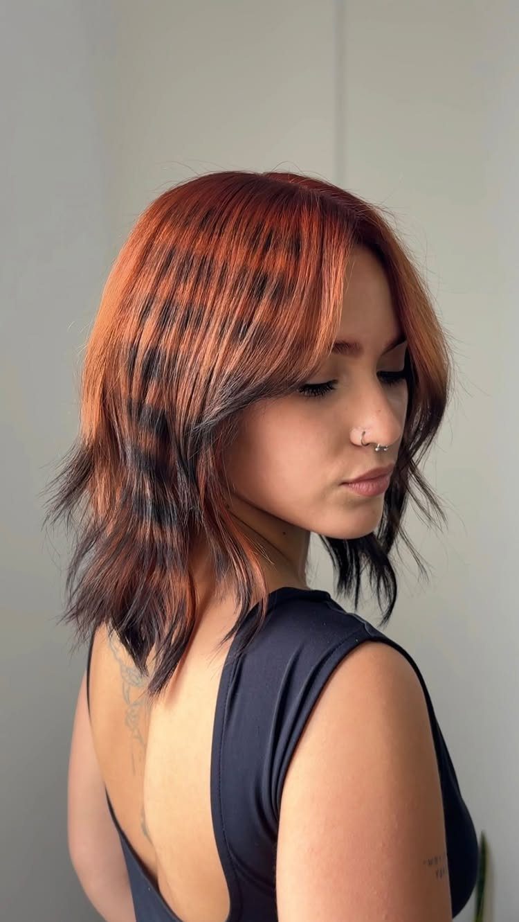 Woman showing feathered copper-highlighted layers with dark, flipped ends