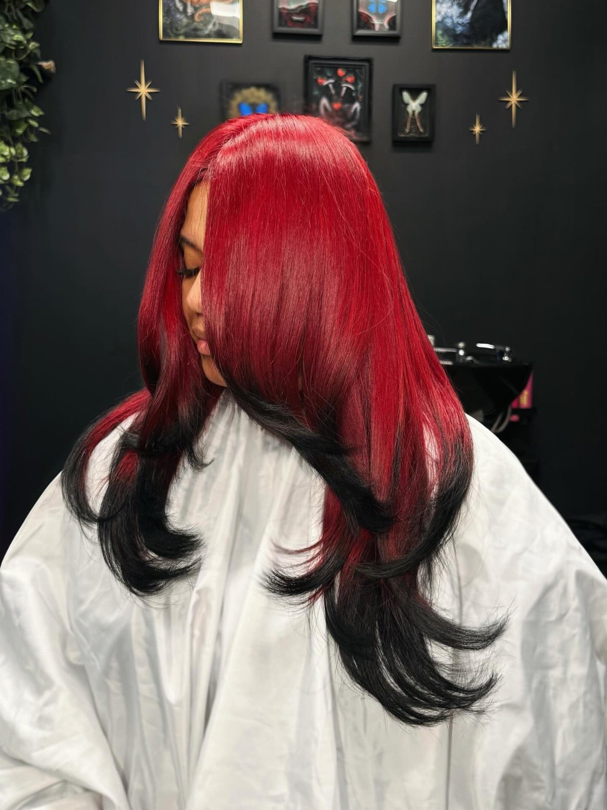 Long red hair fades into loose black curls at the ends