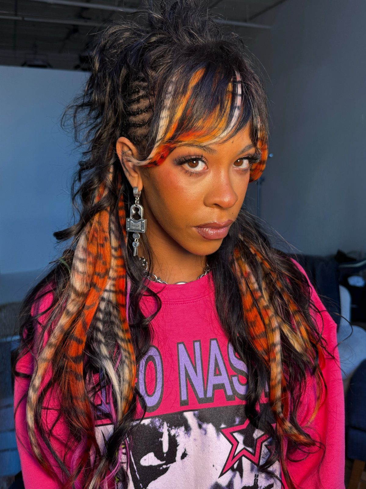 Woman showing long dark hair striped with orange-red and pale blonde highlights