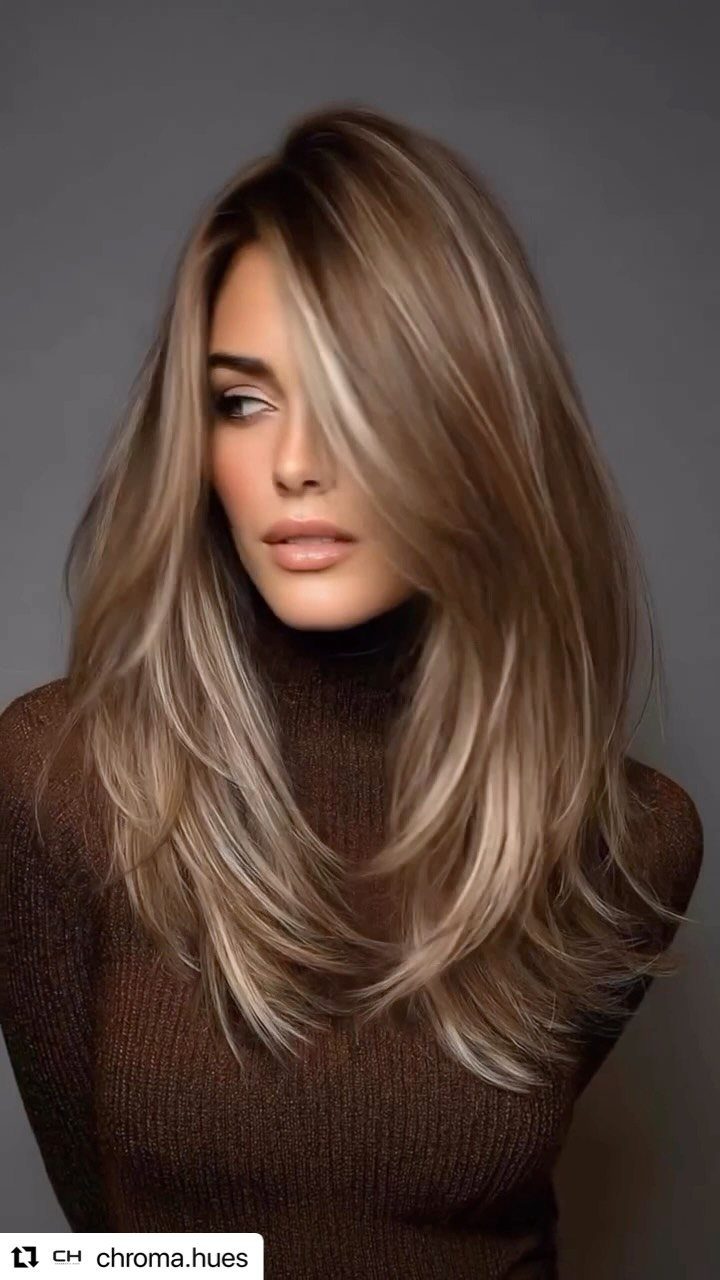 Woman wearing long brunette waves with caramel highlights and layered ends