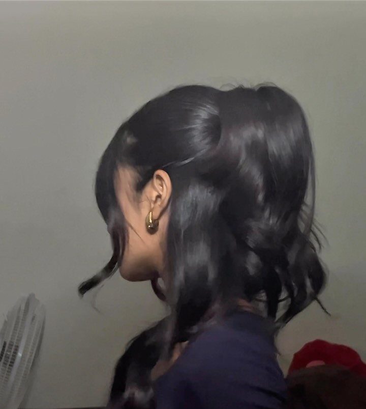 Half-up, half-down dark hairstyle with loose waves and a secured top section