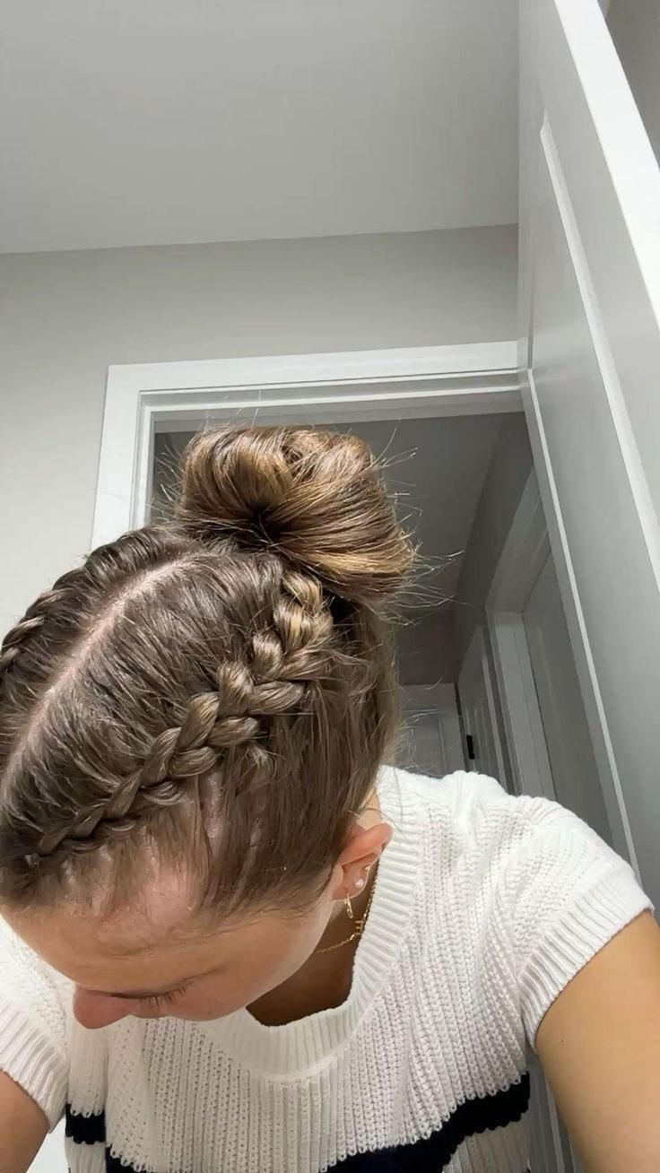 Brown hair braided into a large section and gathered in a high bun
