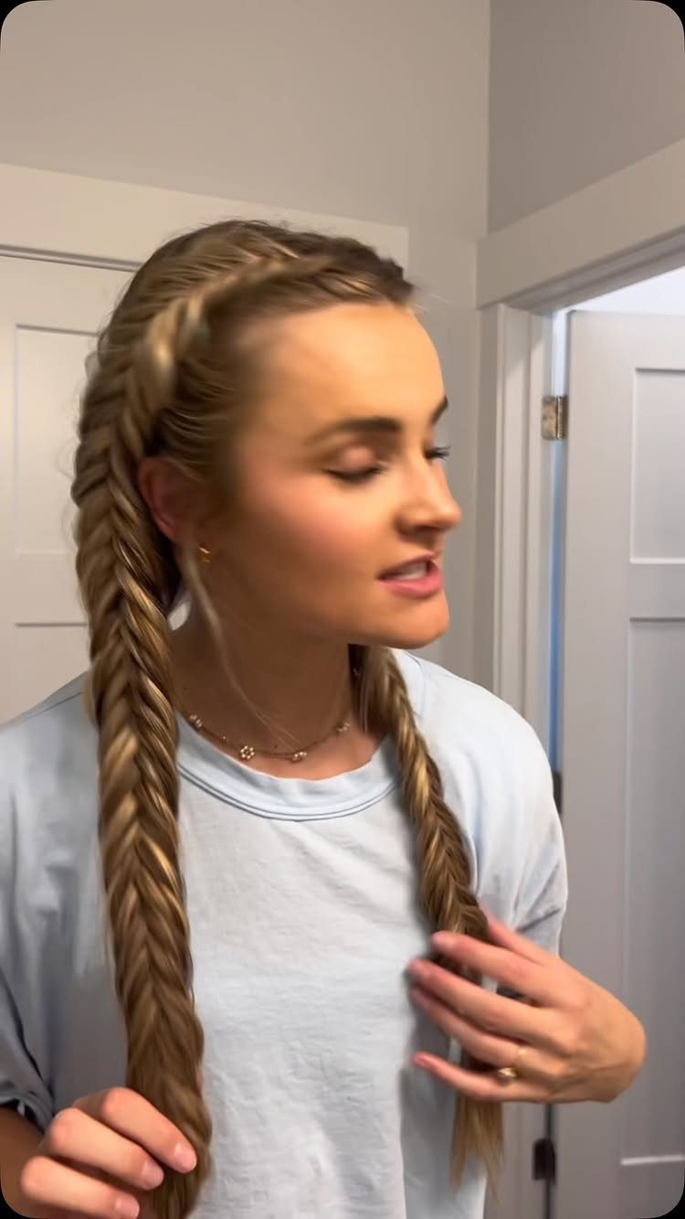 Young woman shows long blonde braids with a braided crown
