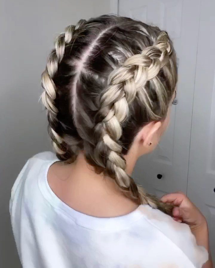 Two thick braids run down either side of a person’s center part