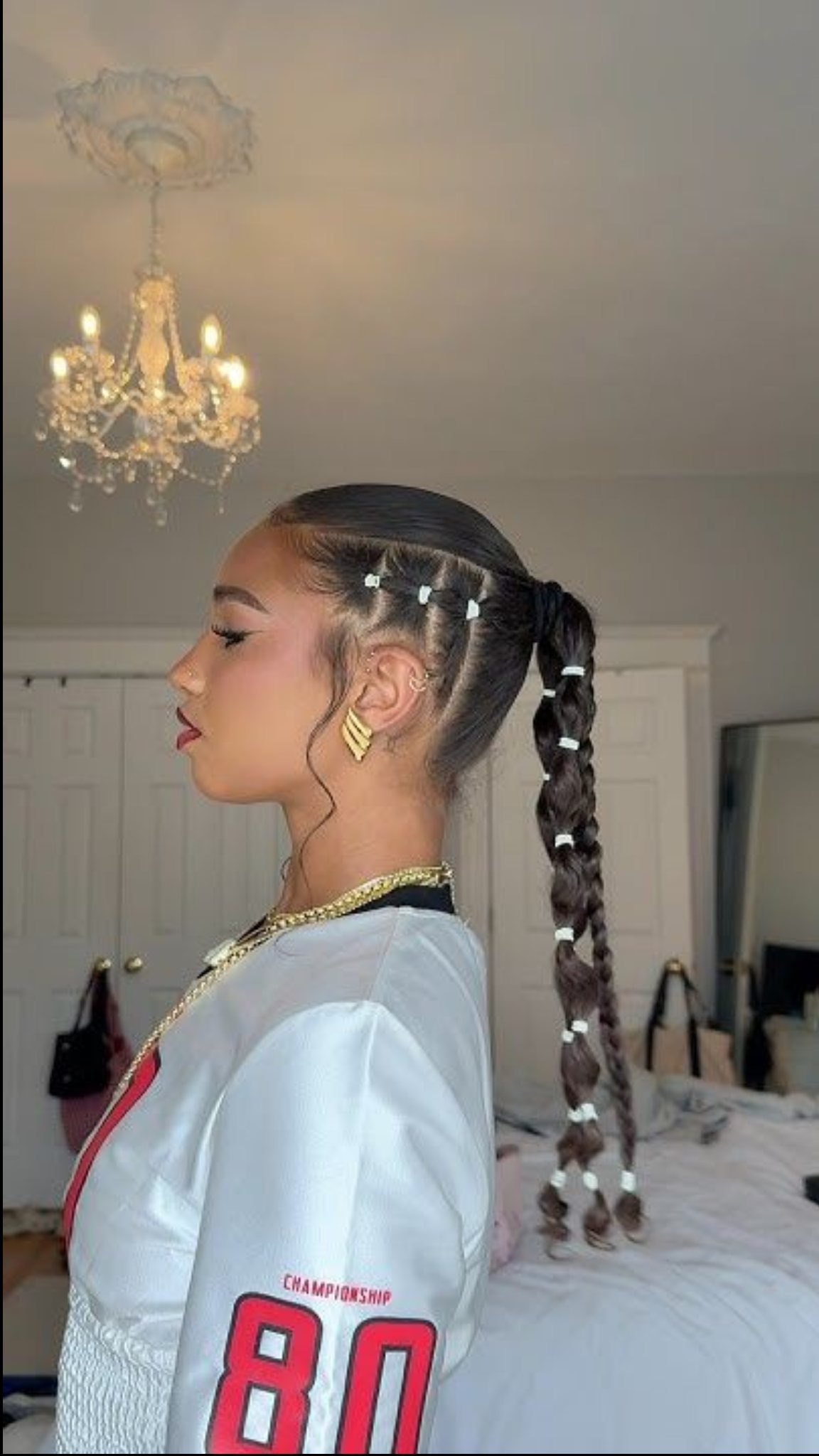 Young woman wearing a high braided ponytail secured with spaced white elastics
