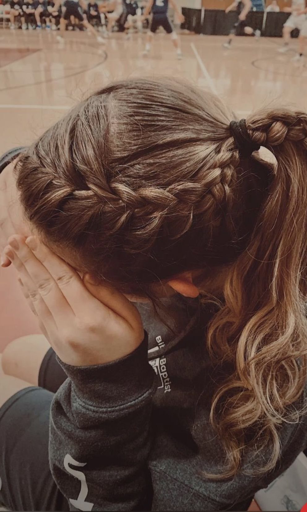 Volleyball player wears a high ponytail gathered with woven side braids
