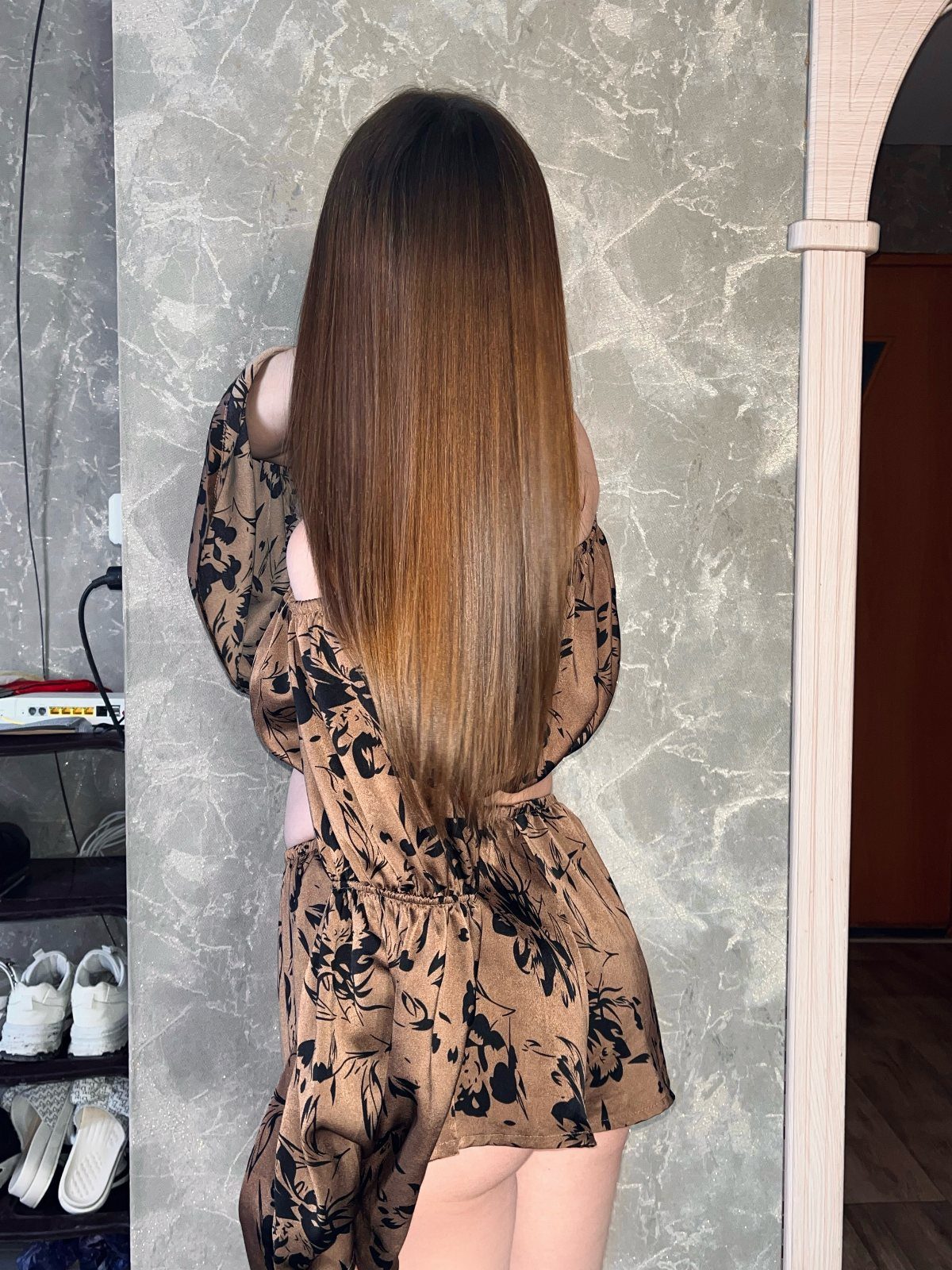 Long, straight brown hair falls evenly from a center part