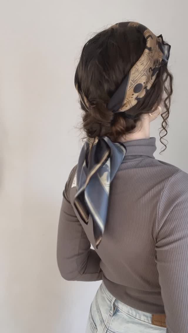 Low pinned updo with a beige patterned scarf tied around the head