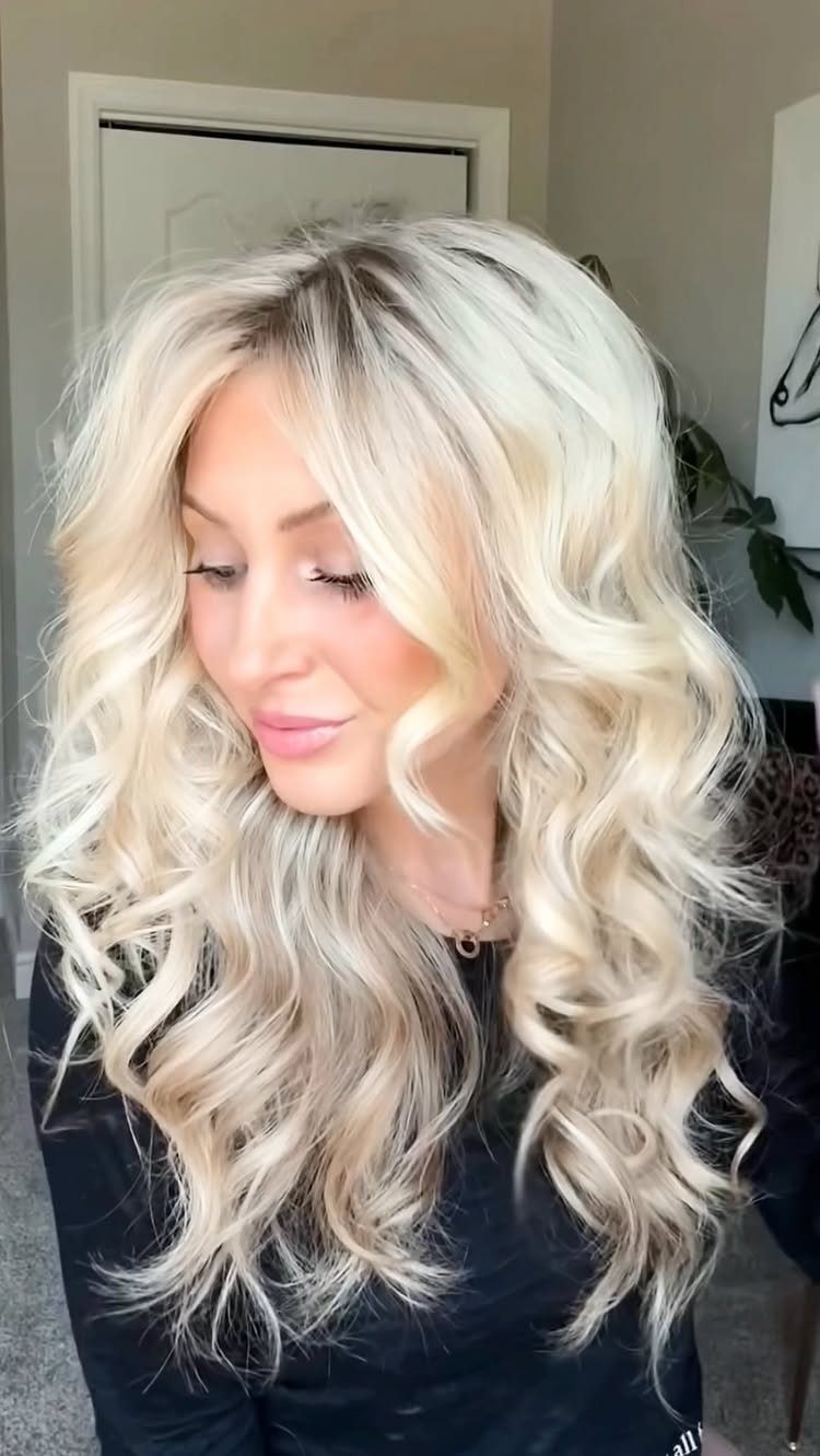 Woman with long platinum-blonde hair styled in loose, tousled beach waves