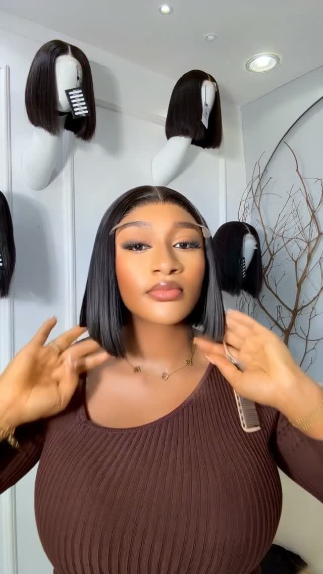 Woman showing sleek, straight shoulder-length hair with blunt ends in a wig display room