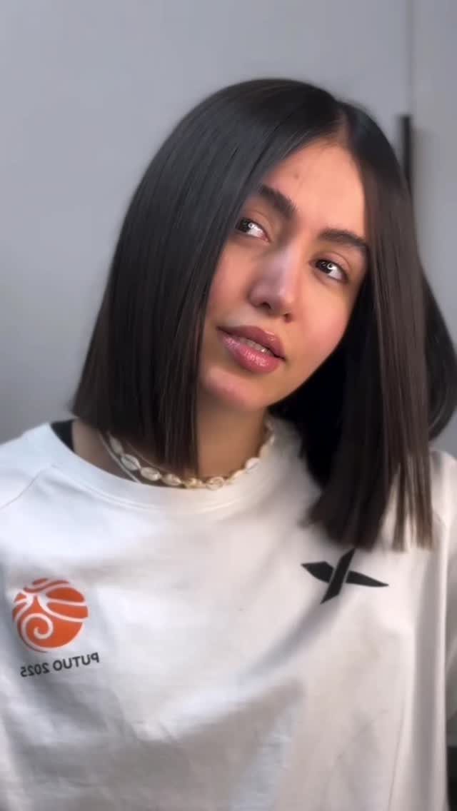 Woman showing a sleek chin-length blunt bob with a center part